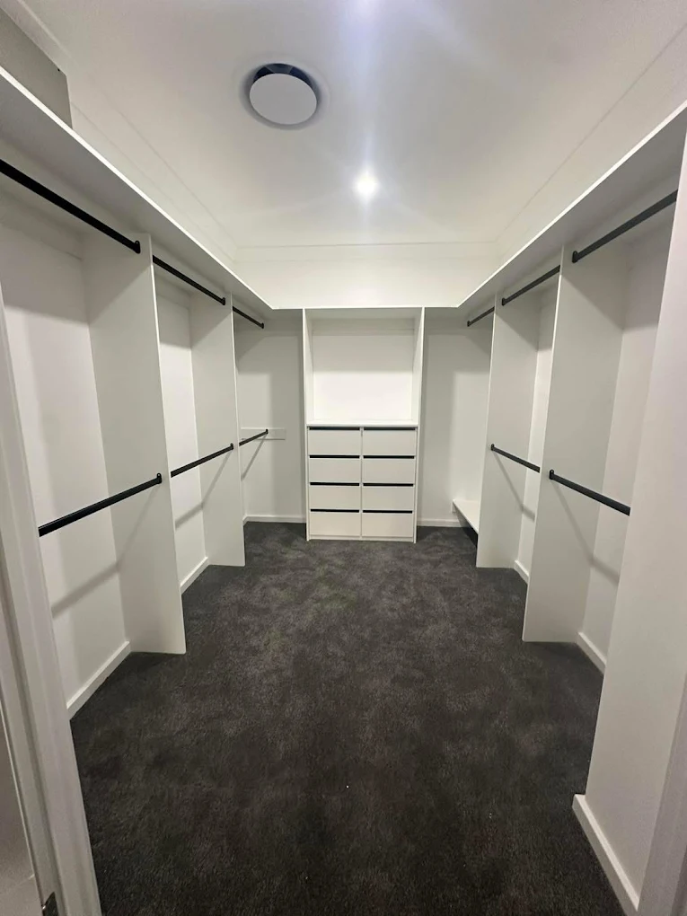 Custom walk-in wardrobe with white shelving and hanging rails